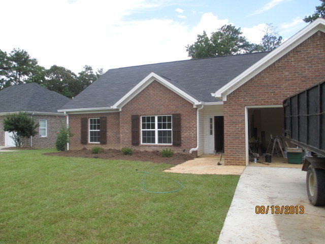 a front view of house with a garden and patio
