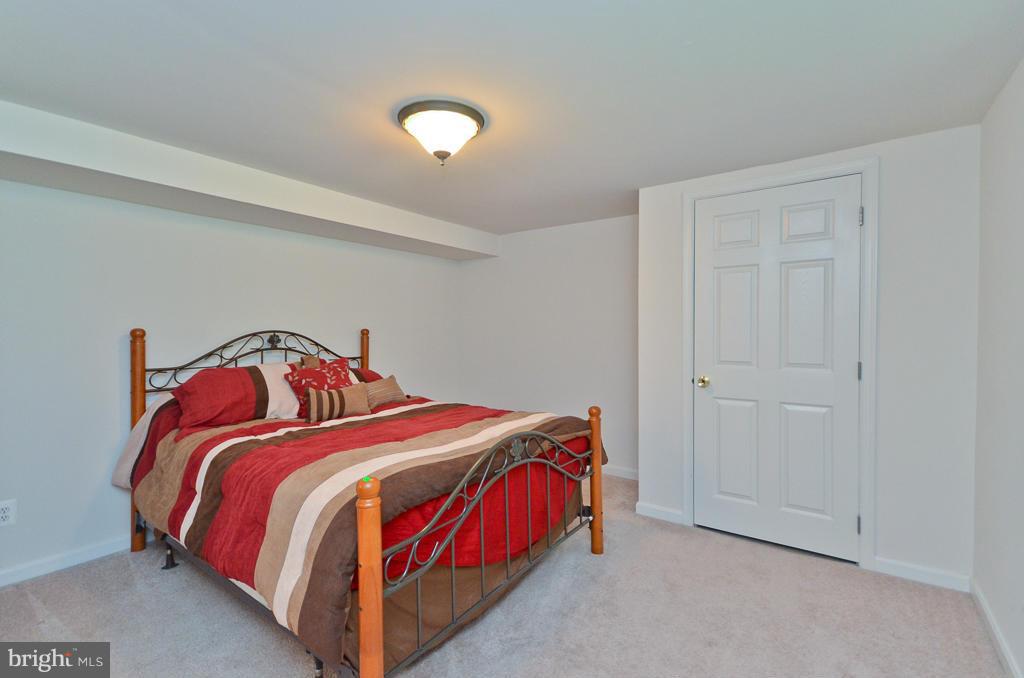 5319 Moultrie Road Springfield, VA 22151 - Photo 22 of 30 a bedroom with a bed and a lamp
