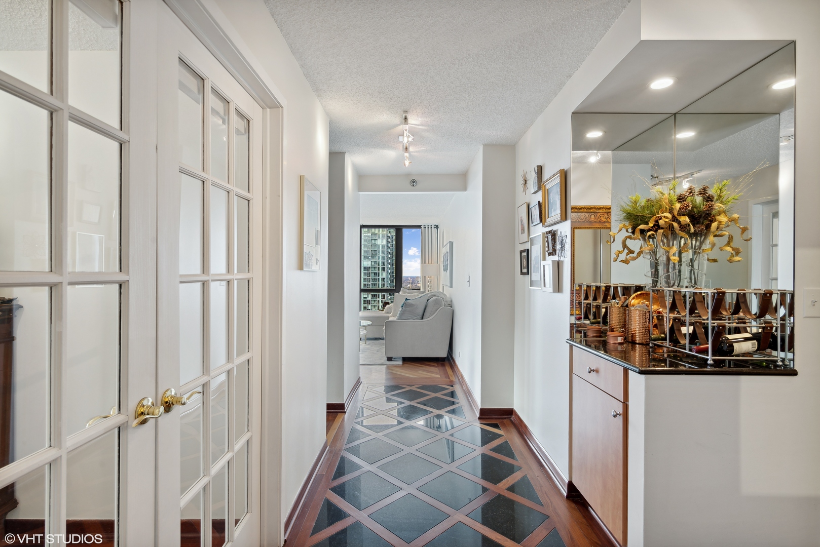 1122 North Clark Street, Unit 3401 Chicago, IL 60610 - Photo 15 of 26 a view of a hallway with a furniture and a chandelier