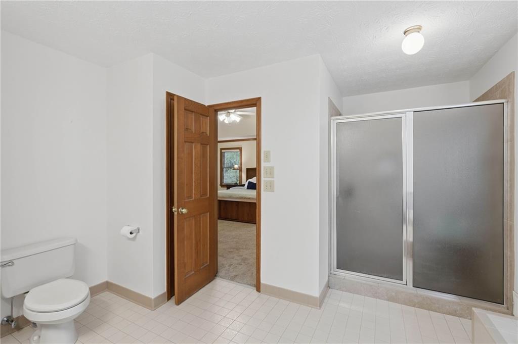 4891 Bill Cheek Road Auburn, GA 30011 - Photo 35 of 99 a bathroom with a granite countertop sink toilet and shower