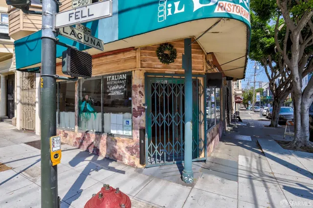 a view of a brick house with large windows and a small yard