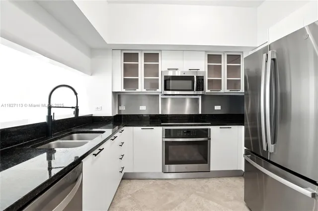 a kitchen with stainless steel appliances granite countertop a stove and a refrigerator
