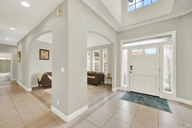 a large kitchen with stainless steel appliances a large counter top a stove and a chandelier