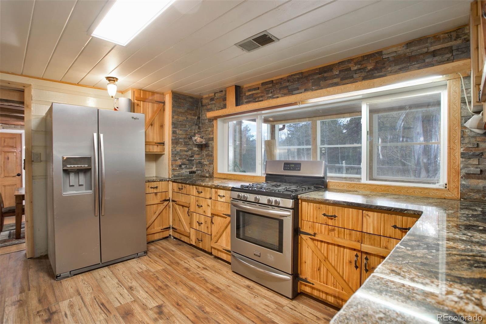 9399 Granzella Road Morrison, CO 80465 - Photo 14 of 41 a kitchen with stainless steel appliances granite countertop a refrigerator and a sink