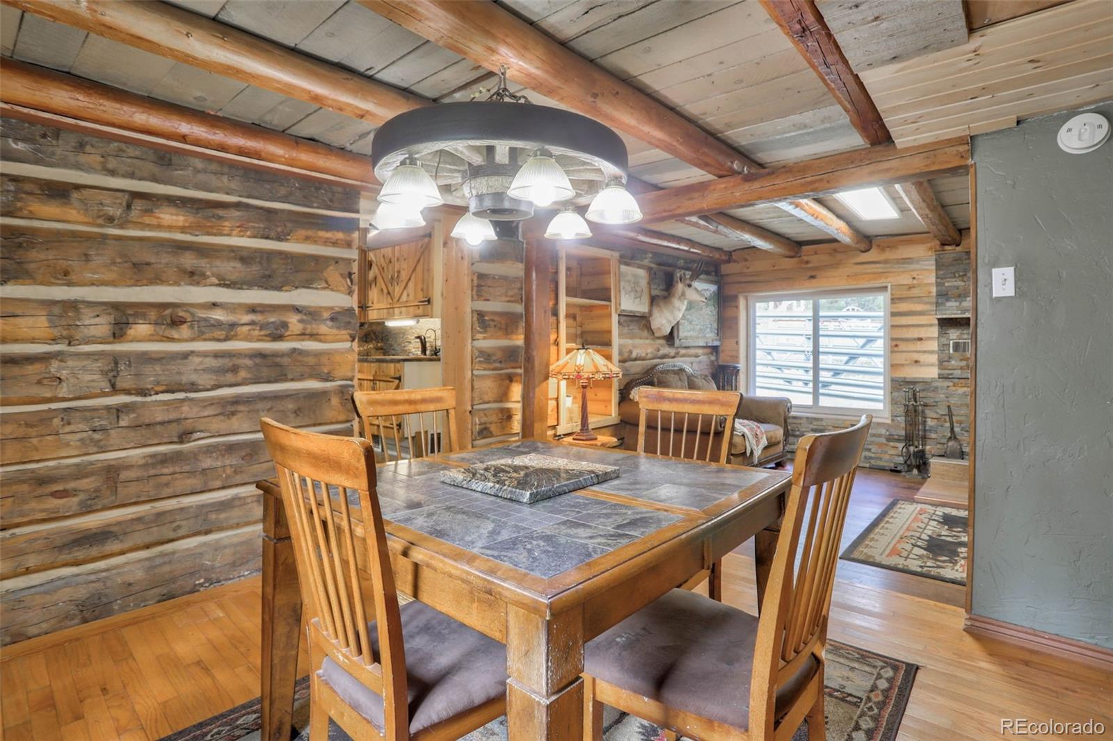 9399 Granzella Road Morrison, CO 80465 - Photo 16 of 41 a view of a dining room with furniture and wooden floor