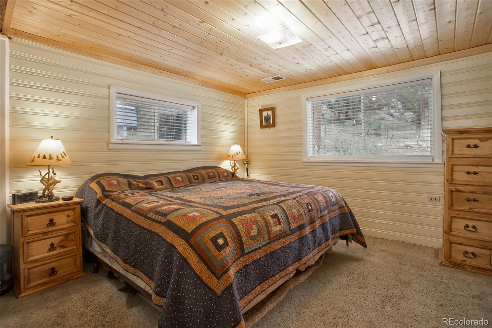 9399 Granzella Road Morrison, CO 80465 - Photo 18 of 41 a bed sitting in a bedroom next to a window
