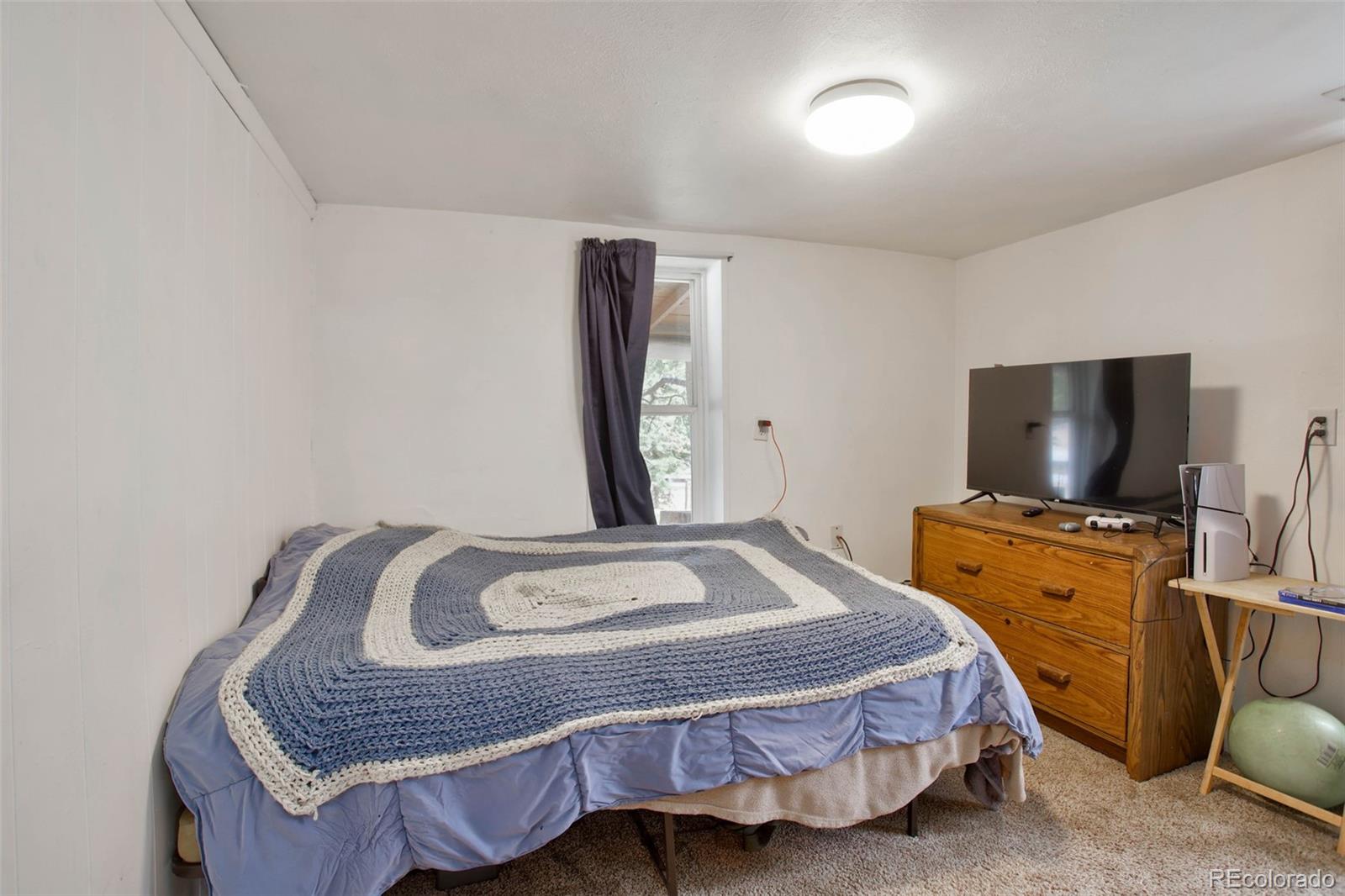 9399 Granzella Road Morrison, CO 80465 - Photo 20 of 41 a bedroom with a bed and flat screen tv