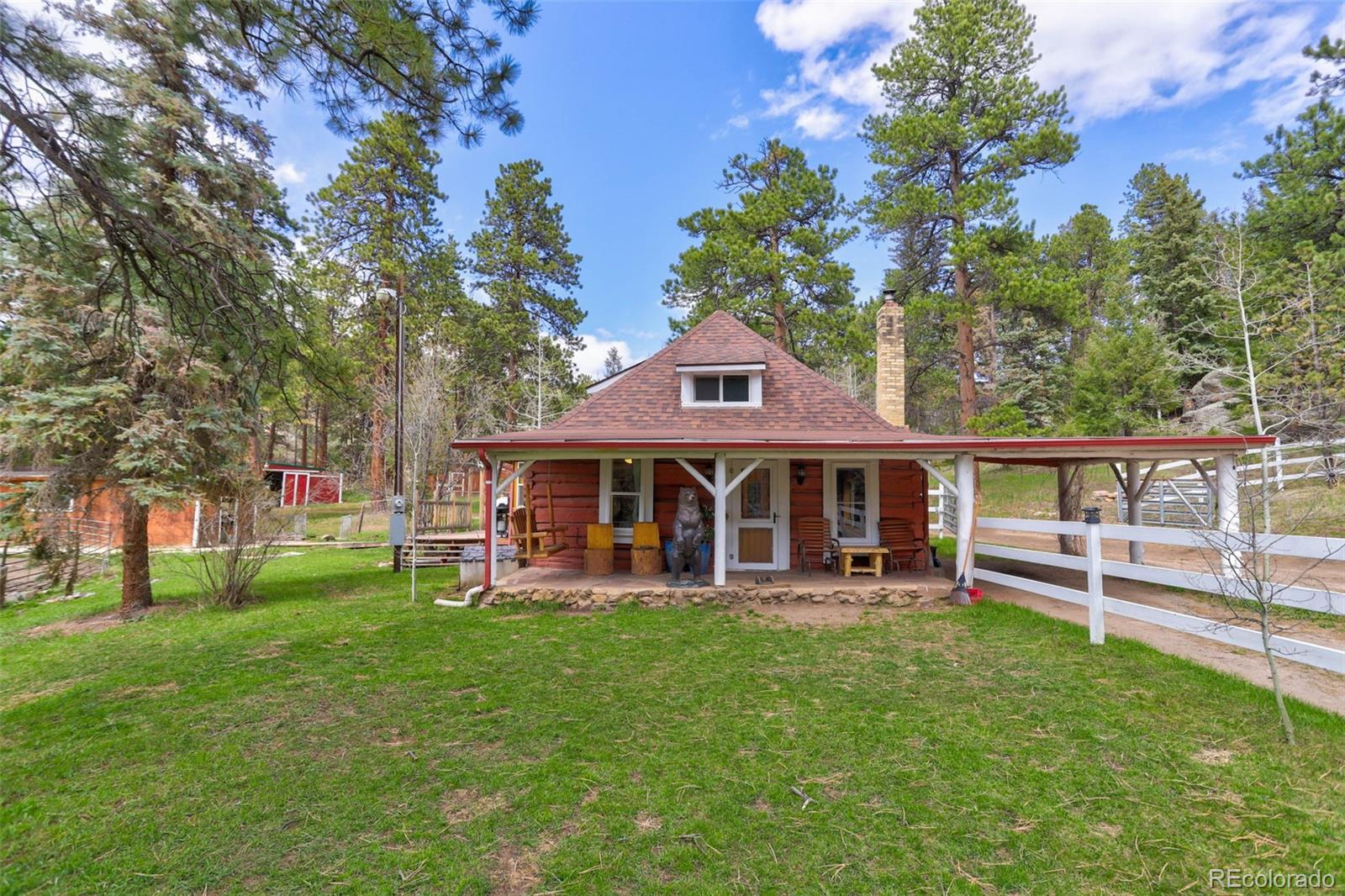 9399 Granzella Road Morrison, CO 80465 - Photo 2 of 41 front view of a house with a yard table and chairs