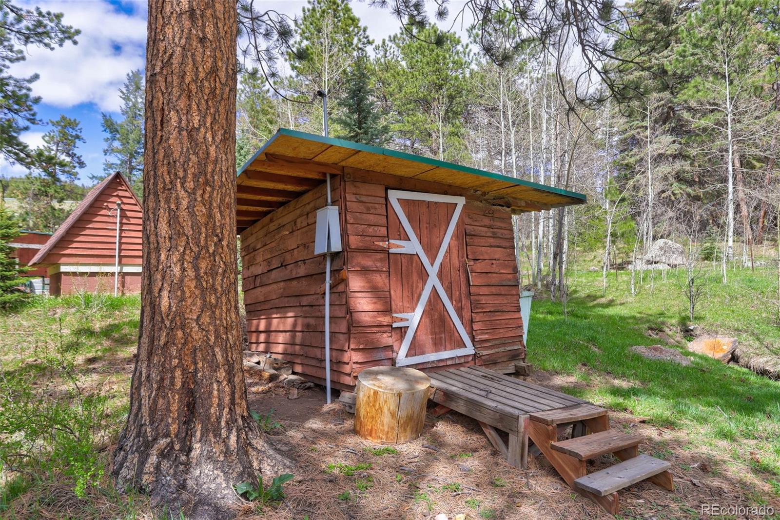 9399 Granzella Road Morrison, CO 80465 - Photo 26 of 41 a wooden bench sitting in front of a house