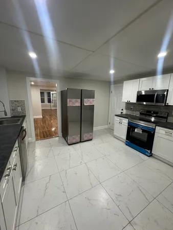 a kitchen with stainless steel appliances granite countertop a stove a sink and a refrigerator