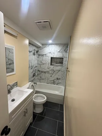a bathroom with a sink a toilet a mirror and shower