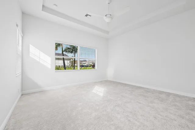 an empty room with windows and fireplace