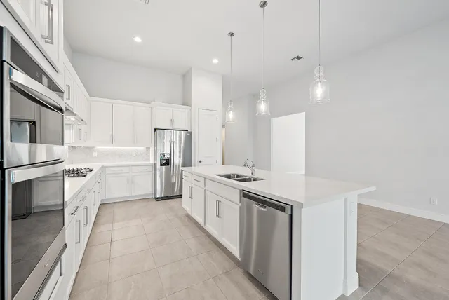 a kitchen with white cabinets appliances and sink
