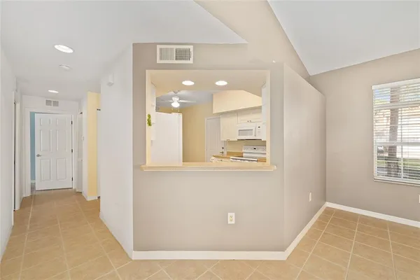 a view of a hallway with wooden floor and a living room