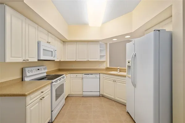 a kitchen with white cabinets white stainless steel appliances and sink