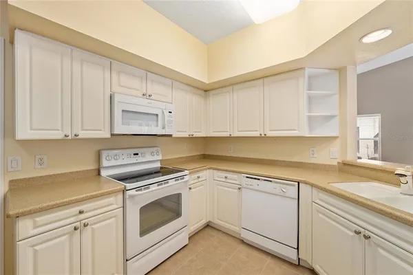 a kitchen with white cabinets and white appliances
