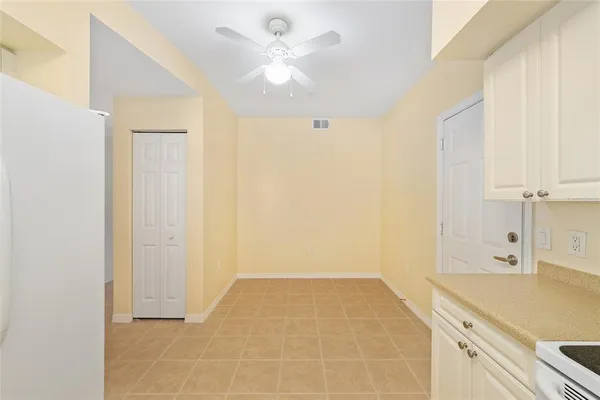 a kitchen with a refrigerator a sink and dishwasher with white cabinets