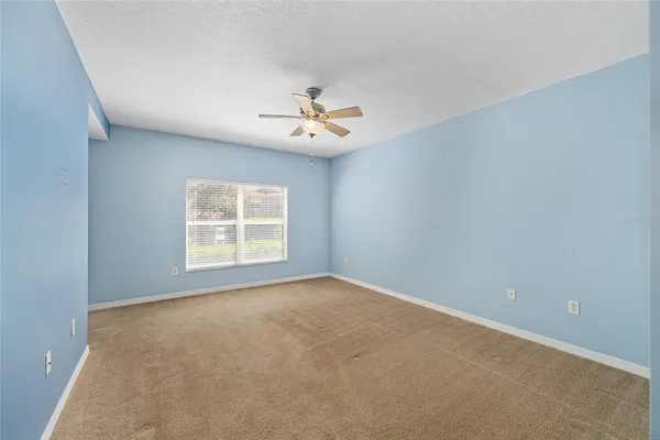 a view of an empty room with a ceiling fan