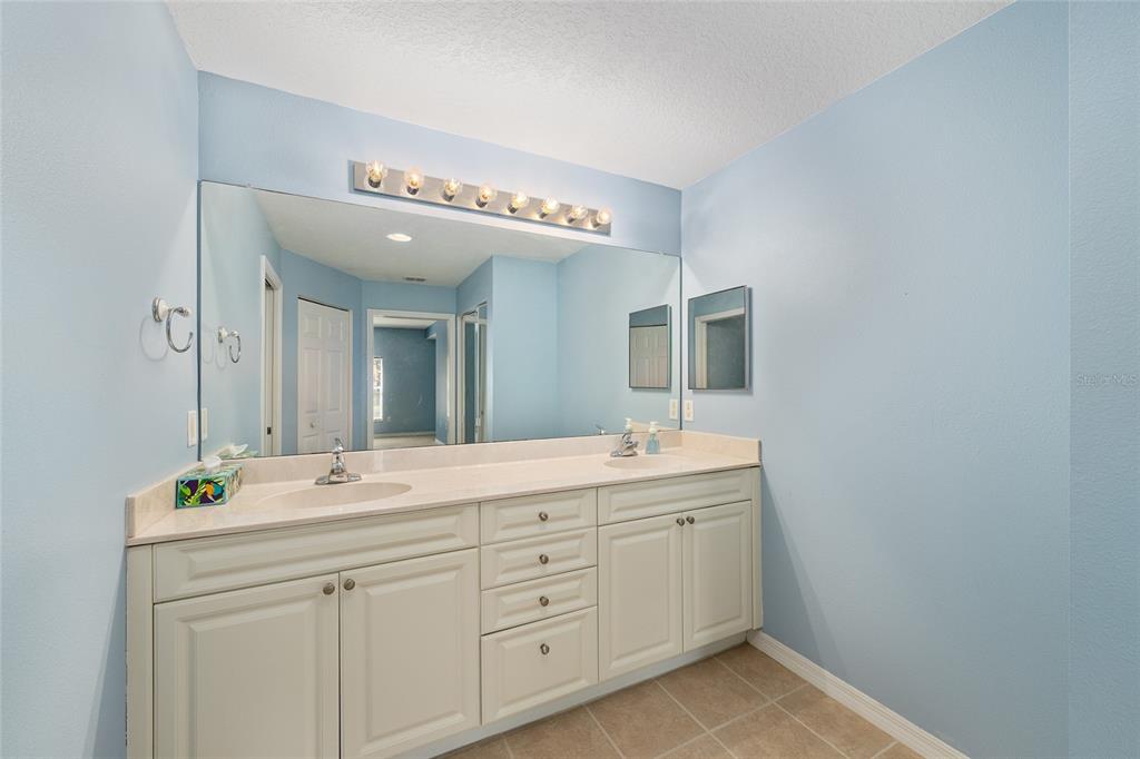 5427 Compass Point, Unit 1 Oxford, FL 34484 - Photo 25 of 51 a spacious bathroom with a granite countertop sink and a mirror