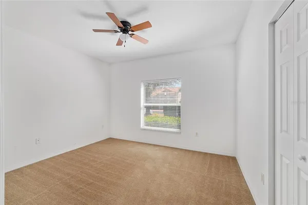 an empty room with chandelier fan