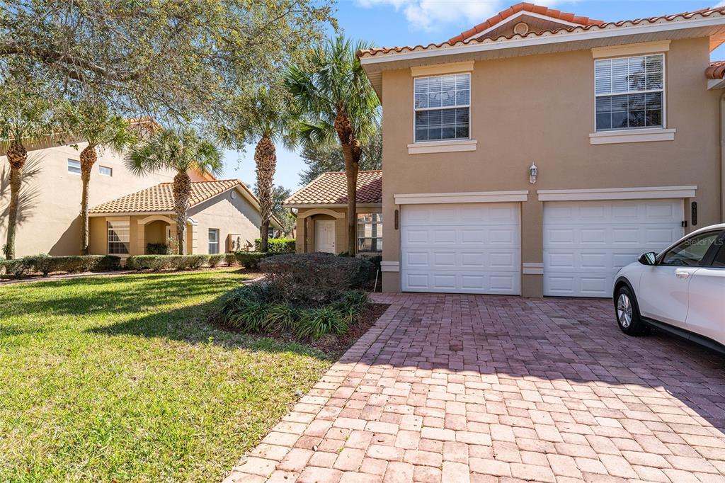 5427 Compass Point, Unit 1 Oxford, FL 34484 - Photo 4 of 51 a view of a white house with a yard plants and large tree