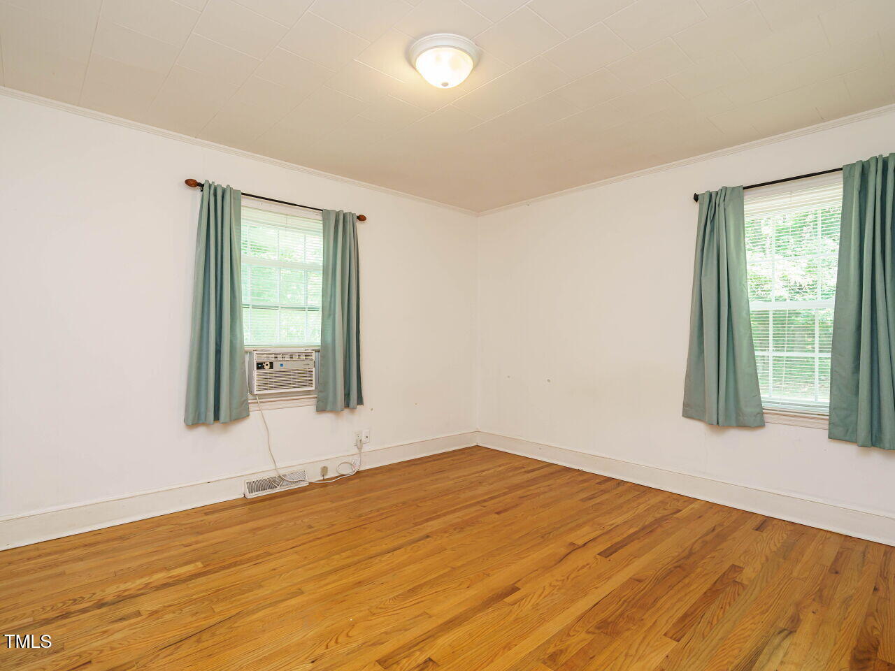 1191 Old Sanford Road Moncure, NC 27559 - Photo 19 of 30 an empty room with wooden floor and windows
