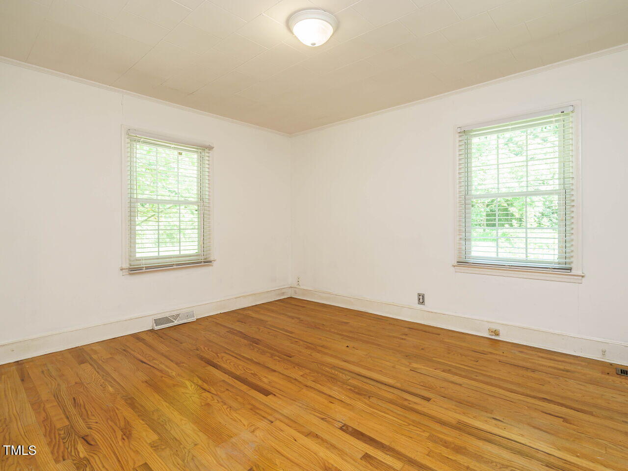 1191 Old Sanford Road Moncure, NC 27559 - Photo 22 of 30 an empty room with wooden floor and windows