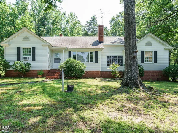 a house with green field in front of it