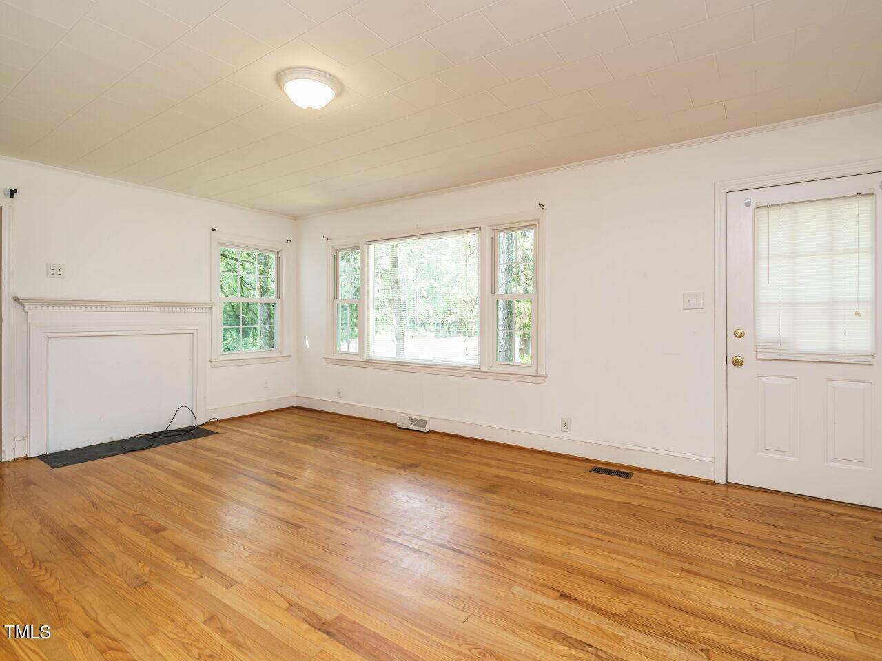 1191 Old Sanford Road Moncure, NC 27559 - Photo 5 of 30 an empty room with wooden floor and windows