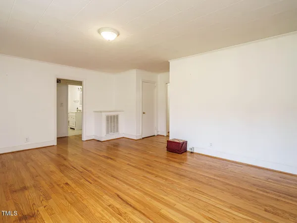 a view of empty room with wooden floor