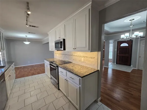 a kitchen with stainless steel appliances granite countertop a sink and a stove