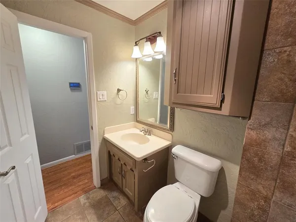 a bathroom with a toilet a sink a mirror and vanity