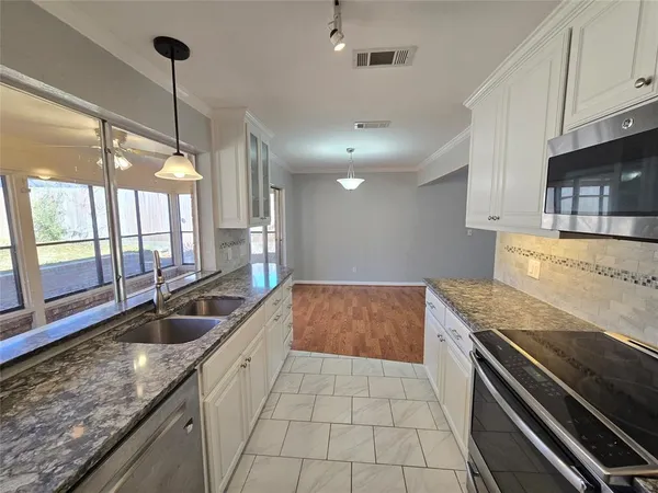 a kitchen with granite countertop a sink and a stove