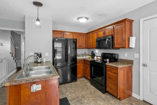 a kitchen with granite countertop a refrigerator a stove and a sink