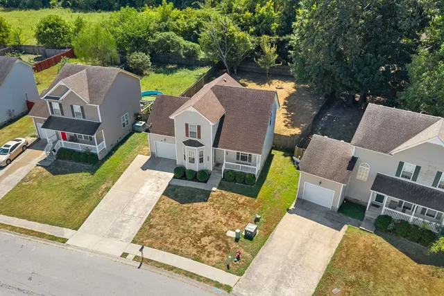 an aerial view of a house with swimming pool and porch