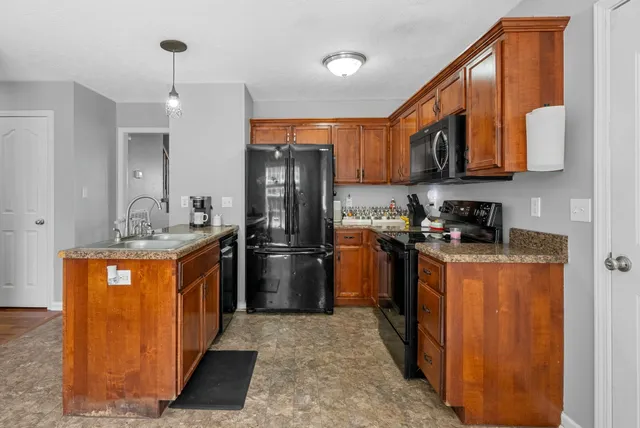 a kitchen with stainless steel appliances granite countertop a refrigerator a stove top oven a sink and dishwasher