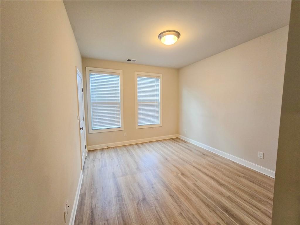 1758 Glenview Park Circle Duluth, GA 30097 - Photo 28 of 45 an empty room with wooden floor and windows