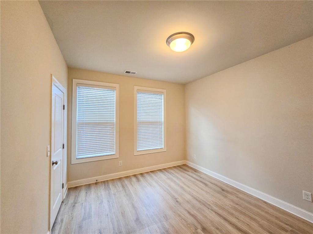 1758 Glenview Park Circle Duluth, GA 30097 - Photo 29 of 45 an empty room with wooden floor and windows