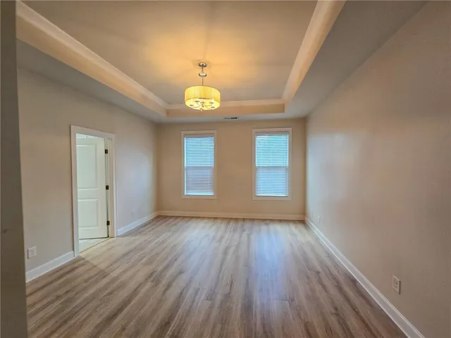 a view of empty room with wooden floor and window