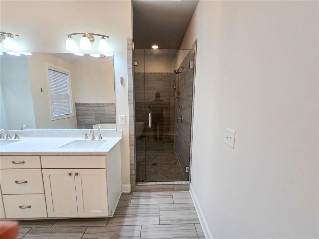 1758 Glenview Park Circle Duluth, GA 30097 - Photo 10 of 45 a bathroom with a granite countertop sink a mirror and a shower