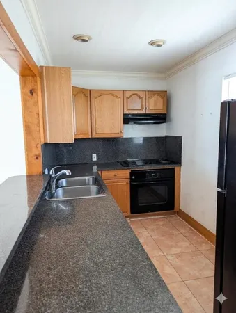 a kitchen with granite countertop a refrigerator and a sink