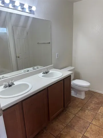 a bathroom with a sink a toilet a mirror and vanity