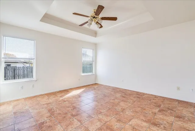 an empty room with a window and a fan