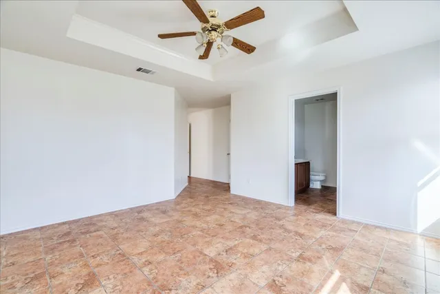 an empty room with closet and a ceiling fan