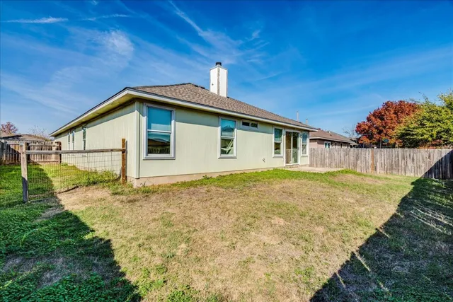 a view of a backyard with wooden fence