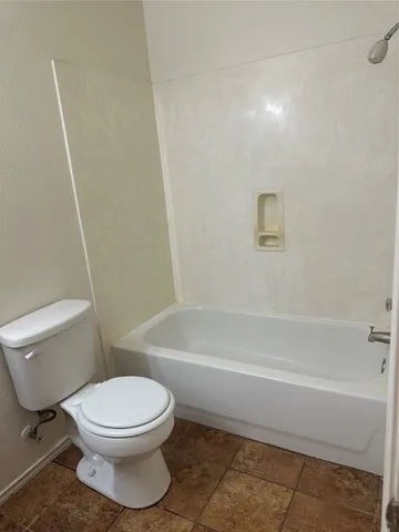 a bathroom with a toilet and a bath tub