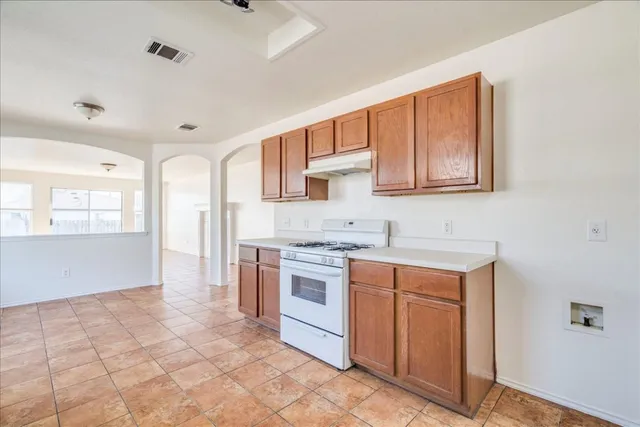 a kitchen with stainless steel appliances granite countertop a stove a sink and a refrigerator