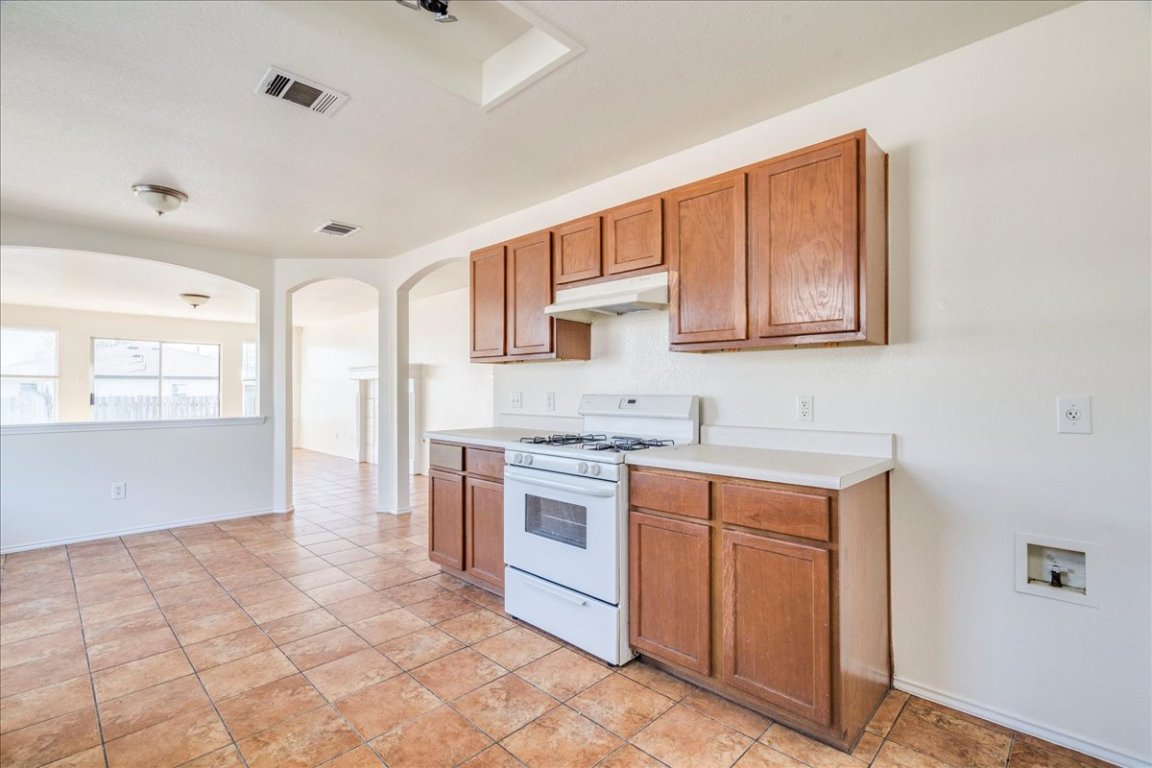 116 Keegans Way Kyle, TX 78640 - Photo 9 of 30 a kitchen with stainless steel appliances granite countertop a stove a sink and a refrigerator