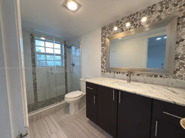 a bathroom with a double vanity sink toilet and a mirror