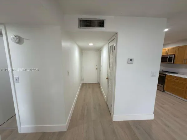 a view of a hallway with wooden floor and a sink